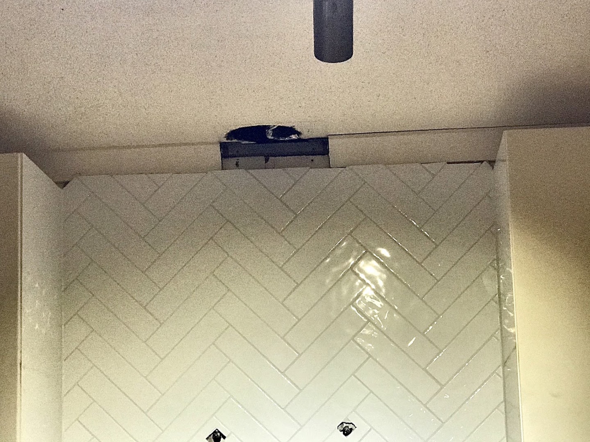 A tiled shower niche ceiling seen from below