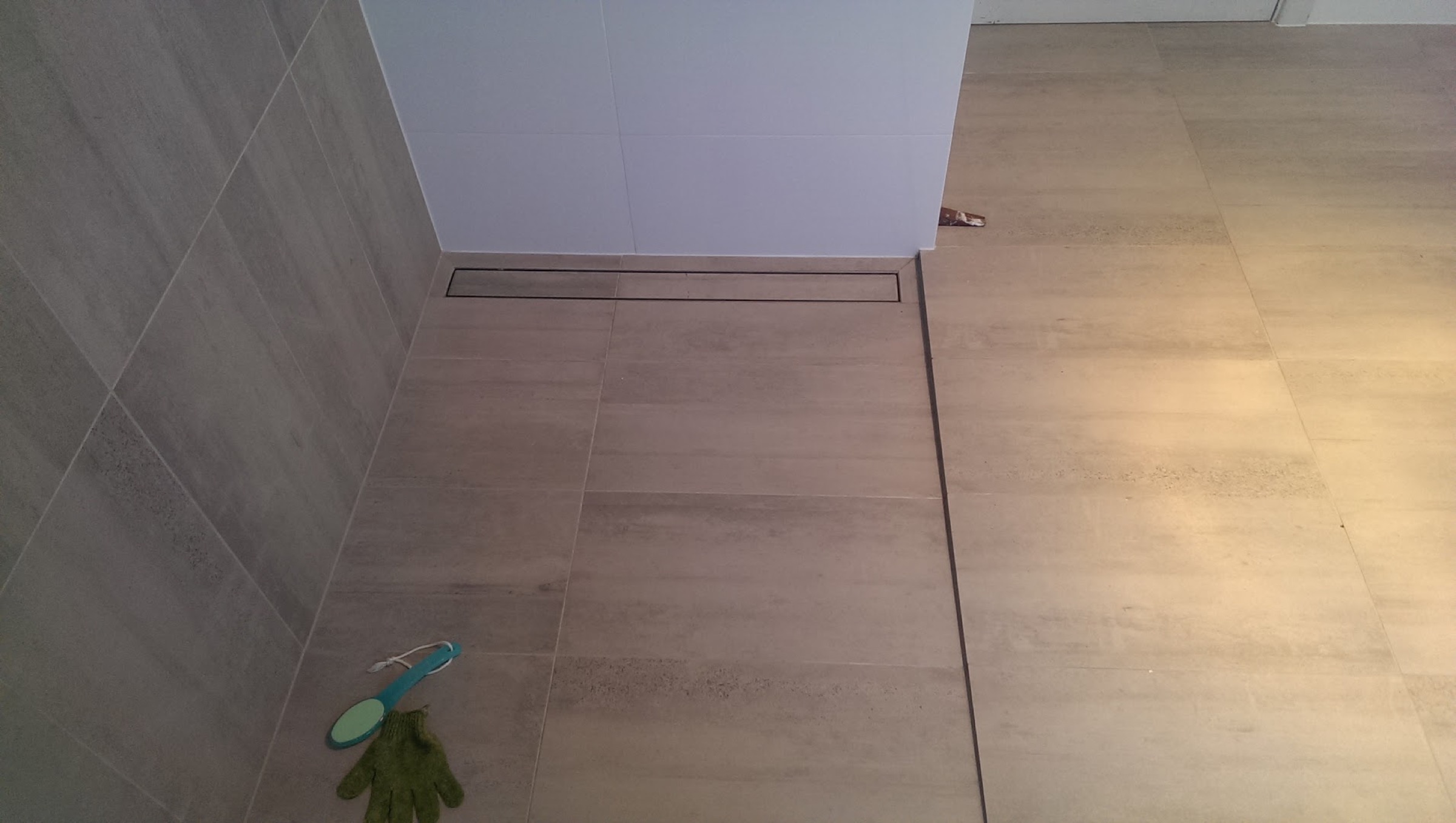 A tiled hallway floor opening onto an outdoor deck through glass doors