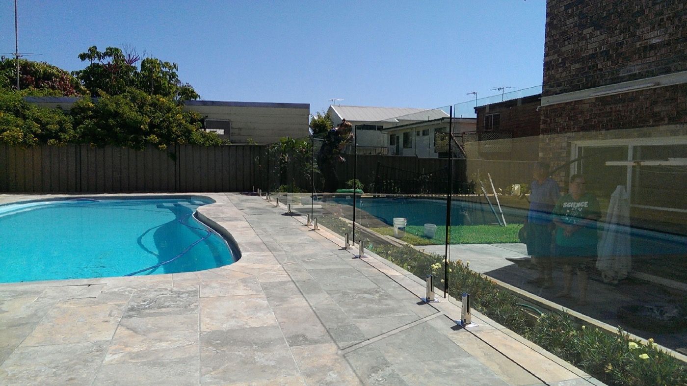 Grey travertine paving around a backyard swimming pool