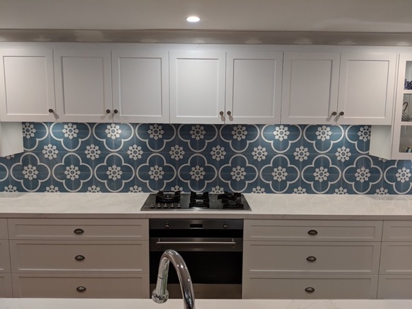A kitchen with a blue and white patterned tile splashback