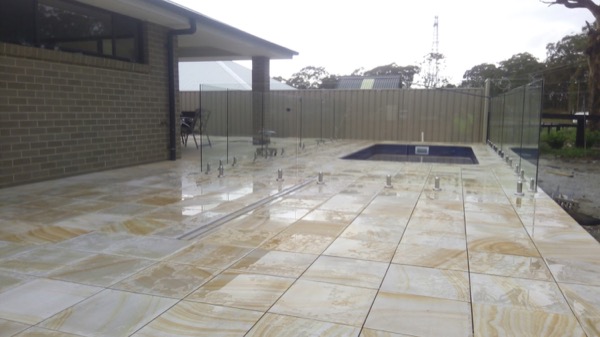 Travertine paving laid around a rectangular backyard pool
