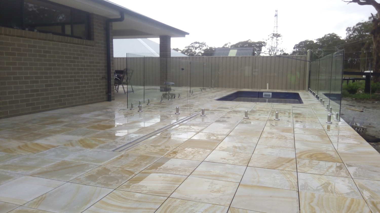 Travertine paving laid around a rectangular backyard pool